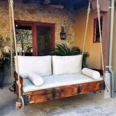 a white couch sitting on top of a wooden swing