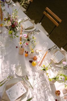 the table is set with flowers and candles