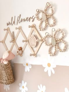 there is a wall with flowers on it and some toys hanging from the hooks above