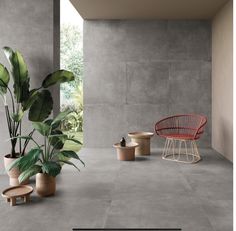 a room with concrete floors and potted plants