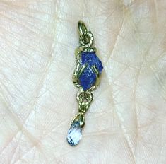 "Please go to my Instagram to watch the video about this pendant ~ A lovely genuine purple-blue color tanzanite glistens in a hollow 14k yellow gold wire bezel. Set with a light blue color sapphire bead is so fiery, vibrant and intense! A unique little piece with so much character. All handcrafted by me in my Michigan studio. Gem: approx. 12mm x 7mm / 2.15ct / genuine purple-blue tanzanite / with inclusions and imperfection surface 6mm x 3mm/ genuine light blue bead / with inclusions and imperfe Boulder Opal Ring, 14k Yellow Gold Necklace, Halo Necklace, Blue Tanzanite, Sapphire Pendant, Argentium Silver, White Topaz, Blue Beads, Opal Rings