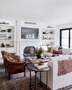 a living room filled with lots of furniture and a flat screen tv mounted on the wall