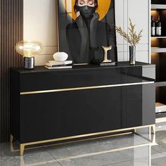 a black and gold sideboard with an art print on it's face in the background