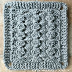 a crocheted square is sitting on the floor