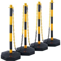 three black and yellow poles with chains on them