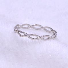 a silver ring sitting on top of a white surface