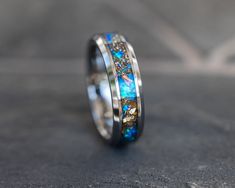 a wedding band with blue opal and gold inlays on the inside of it