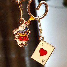 a keychain with a rabbit holding a playing card on it's back