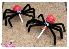 two spider lollipops with googly eyes are sitting on the ground next to each other