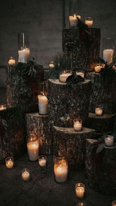 many lit candles are placed on wood logs