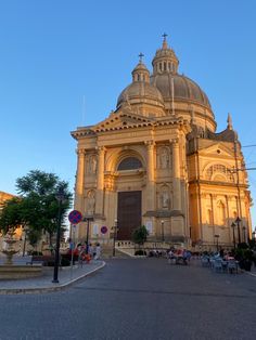 an old church with people sitting at tables in front