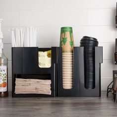 there are many items in the holder on the counter top, including drinks and paper towels