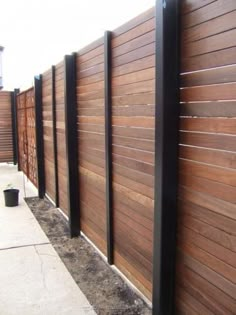 a wooden fence next to a sidewalk