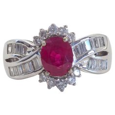 Beautiful and peak unique cocktail ring boasts a lovely oval ruby at the center! The ruby is an oval cut and is bright with high saturation of color and with natural inclusions. There are numerous tapered baguette and round melee diamonds accenting the ring. The diamonds are of good quality and is very lively. The ruby has been certified and come with a vintage certificate from AIGS. Product Details: Metal: 18k Solid Gold Metal Color: White Gold Ruby: Natural, pinkish- red, oval cut, heat-treatm Luxury Oval Cabochon Ruby Ring, Luxury Ruby Ring With Vs Clarity, Oval Shape, Luxury Ruby And Diamond Oval Cabochon Ring, Luxury Vintage Oval Cabochon Ruby Ring, Luxury Multi-stone Oval Ruby Ring, Unique Cocktails, Diamond Cocktail Rings, Oval Cut, Cocktail Rings