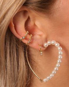 a close up of a person wearing ear rings with pearls on it's sides