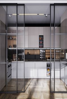 an open kitchen with glass walls and wooden floors