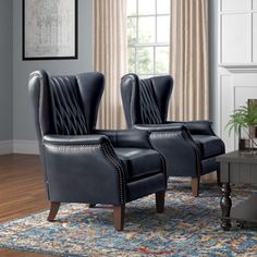 two black leather chairs sitting on top of a rug