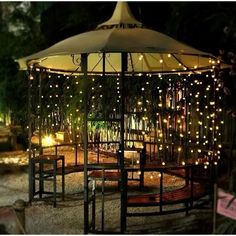 an outdoor gazebo with lights on it at night