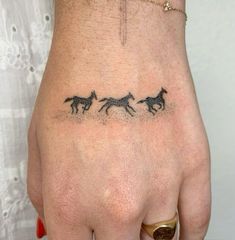 a woman's left hand with three horses on it and the word love written in black ink