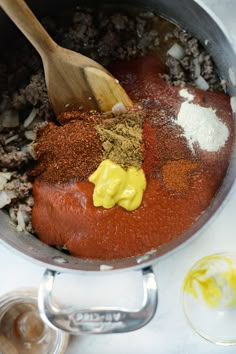 the ingredients are being mixed together in the pot for this recipe, including ground beef and spices