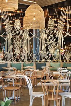 chairs and tables in a restaurant with hanging lights