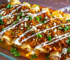 an enchilada dish with sauce, cheese and parmesan on top