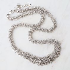 This unique & delicate jewelry is made from pieces of very fine ball chain that are laser soldered by hand to create detailed, beautiful patterns. It is soft and fluid, with a "silk"-like feeling. Adds a textured, wearable, and unique touch to any look! Woven ball chain Rhodium plated sterling silver 17" with 1.5" extender Lobster clasp Handmade in Thailand, handpicked in person by our buyers Silver Multi-strand Necklace With Satellite Chain, Silver Beaded Chain Necklace For Wedding, Wedding Silver Beaded Chain Necklace, Delicate Silver Multi-strand Necklace, Silver Satellite Chain Necklace For Wedding, Silver Wedding Necklaces With Satellite Chain, Silver Wedding Necklace With Satellite Chain, Silver Necklaces With Satellite Chain For Parties, Party Necklaces With Silver Satellite Chain