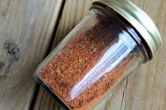 a jar filled with lots of brown stuff on top of a wooden table