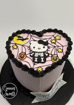 a hello kitty birthday cake on a black plate