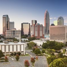 an aerial view of a city with tall buildings in the foreground and parking lot to the right