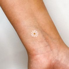 a person's arm with a small white flower on the left side of it