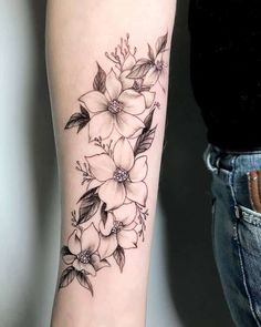 a black and white flower tattoo on the arm