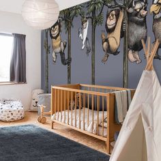 a baby's room decorated in blue and white with animals on the trees wallpaper