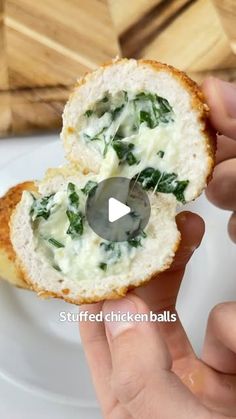 someone is holding up a piece of bread with spinach on it and cheese in the middle