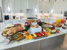 a kitchen filled with lots of food on top of a white counter topped with fruit