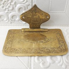 an antique brass plate with ornate designs on it