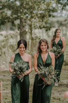 two bridesmaids in green dresses holding their bouquets