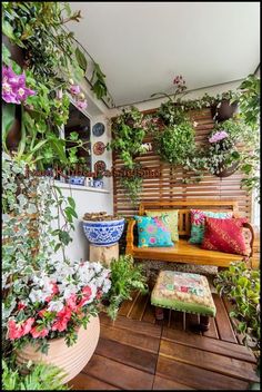 a wooden bench sitting on top of a wooden floor next to potted plants and flowers