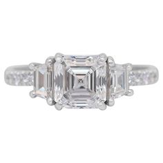 an emerald cut diamond ring with three baguets on each side and two diamonds in the middle