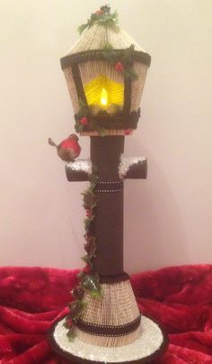 a bird is sitting on top of a cross made out of wicker and decorated with holly