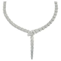 From the renowned Bvlgari of Italy, emerges a masterpiece from their Serpenti collection – an exquisite necklace meticulously crafted in 18-karat white gold. Prepare to envelop yourself in the radiant embrace of 14.74 carats of round brilliant-cut diamonds, each gleaming with an impeccable F color and VVS-VS clarity. This necklace, measuring a graceful 15.3 inches in length, arrives with its original box and authentic Bvlgari paperwork, ensuring its pedigree and prestige. For over seven decades, Serpent Necklace Bulgari, Bvlgari Serpentine Necklace, Serpenti Viper Necklace, Bvlgari Necklace, Bulgari Jewelry, Necklace White Gold, Bvlgari Jewelry, Bvlgari Serpenti, White Gold Necklaces