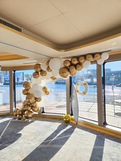 a room filled with lots of windows and balloons hanging from it's ceiling next to a body of water