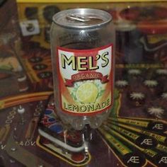 a close up of a glass on a table with a board game in the background