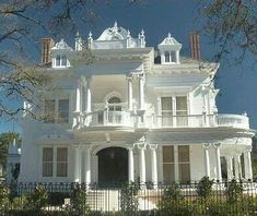 a large white house with many balconies on it's sides and windows