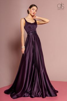 Turn heads in this sleeveless satin gown with sheer embroidered back by Elizabeth K GL2531. This long evening dress features a sleeveless scoop neck bodice with pleated details, beaded waistbands for a touch of sparkle, the sheer back is adorned with lovely floral embroidery, a floor length A-line skirt, and a zipper closure. Affordably priced under $250, this dress is perfect for any formal event and will keep you on budget! Designer: Elizabeth K/GLS Collective Style Number: GL2531 Material: Sa Sleeveless Gowns Evening Dresses, Magenta Formal Dresses Long, Formal Gala Dresses Classy, Purple Gala Dress, Purple Dress Formal Classy, Plum Prom Dress, Satin Gown Designs, Eggplant Bridesmaid Dresses, Eggplant Dress