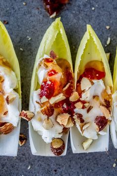 four pieces of banana split with whipped cream and nuts on them, lined up next to each other