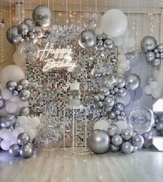 a room filled with silver and white balloons