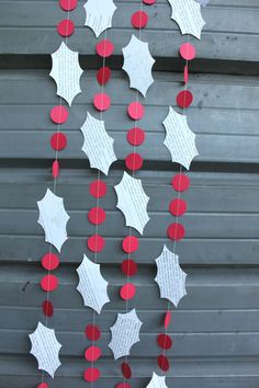 some red and white paper decorations hanging from the side of a building