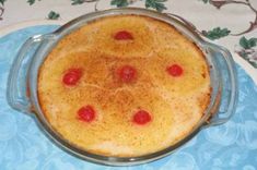 a cake in a glass dish on top of a blue and white cloth covered tablecloth