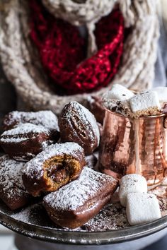 a plate full of doughnuts and pastries with a dog in the background